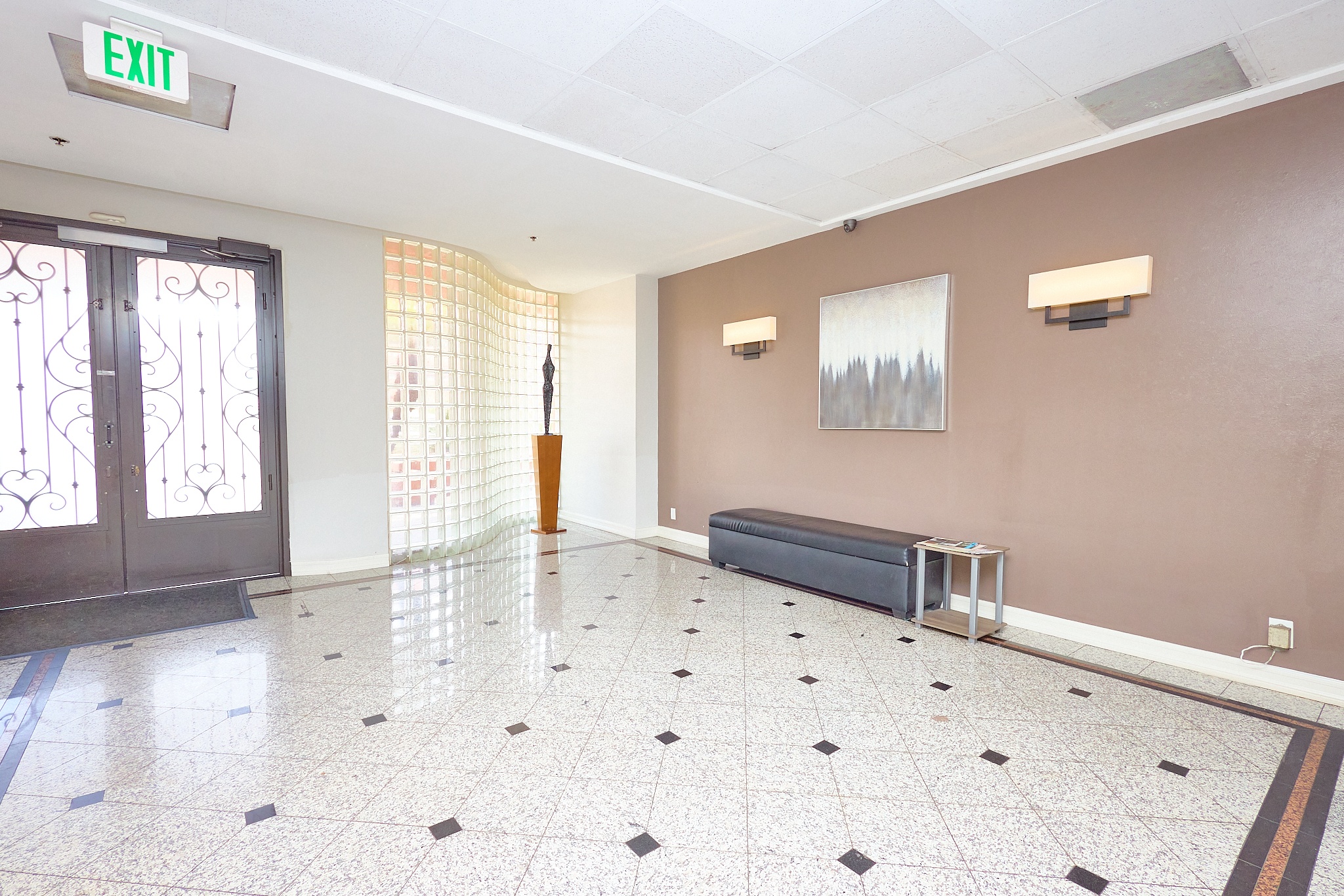 A hallway with a bench and a door with a window.